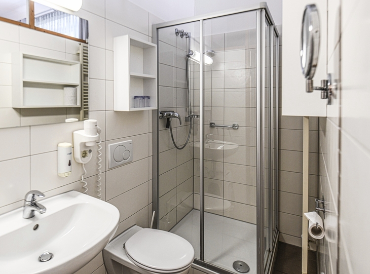 Modernes Badezimmer mit Dusche, Waschbecken und Toilette.