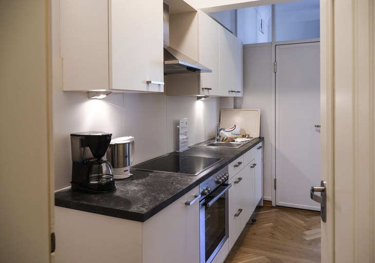 Moderne Küche mit weißer Einrichtung und Elektrogeräten.