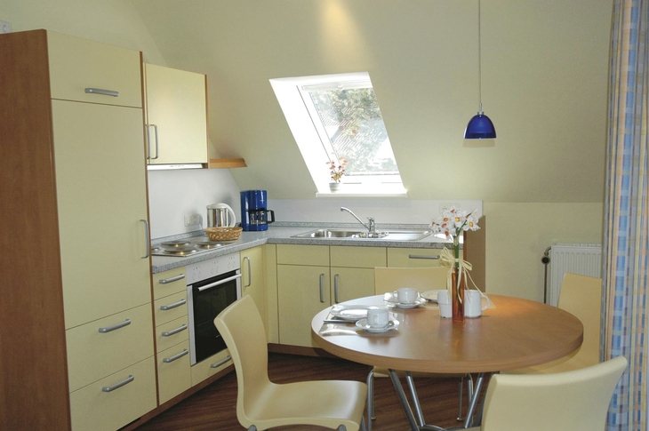 Moderne Küche mit Esstisch, Stühlen, Fenster und Beleuchtung.