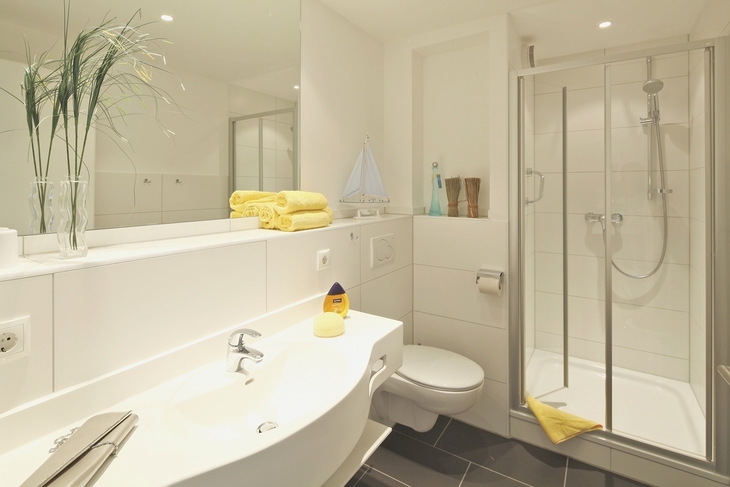 Modernes Badezimmer mit Dusche, Waschbecken und Dekorationen.