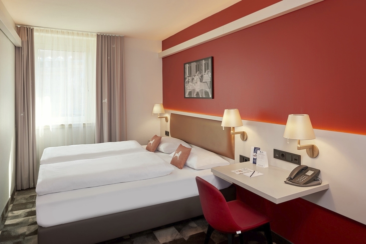 Doppelzimmer im Best Western Hotel Leipzig mit zwei Betten und roter Wand.