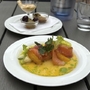 Vorspeise mit Lachs und Zitrusfrüchten auf einem Teller im Freien serviert.