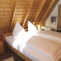 Holzvertäfeltes Schlafzimmer mit Doppelbett und Nachttischlampen.