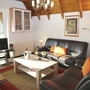 Wohnzimmer mit Ledersofas, Couchtisch, Fernseher und Kunst an der Wand.