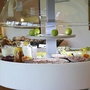 Frühstücksbuffet mit Aufschnitt, Getränken und grünen Äpfeln.