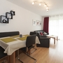 Modern eingerichtetes Wohnzimmer mit Esstisch und Sofa in einer hellen Ferienwohnung.