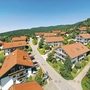 Luftaufnahme von Ferienwohnungen in Bodenmais, umgeben von Hügeln und Wald.