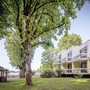 Außenansicht des Seehotel Grunewald mit Bäumen und Gartenanlage.