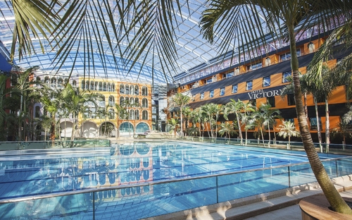 Außenansicht des Hotel Victory Therme Erding bei Tag mit Pool.