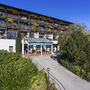 Außenansicht des AktiVital Hotels mit umliegender Gartenanlage und blauen Himmel.