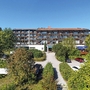 AktiVital Hotel inmitten von Bäumen mit klarem Himmel im Hintergrund.