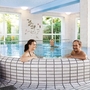 Personen entspannen im Innenpool eines Thermalbads.