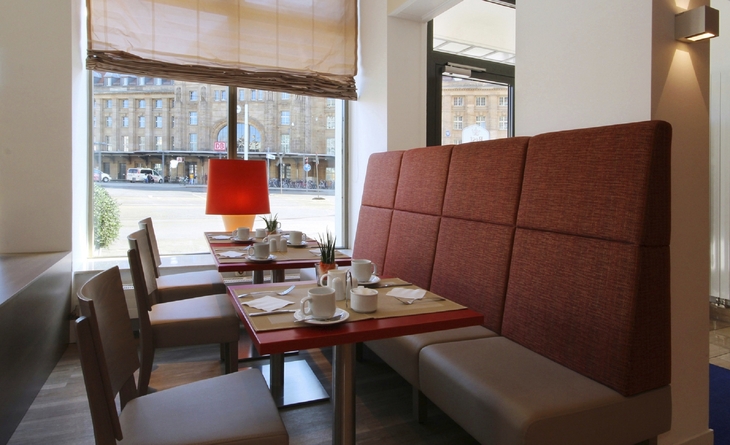 Sitzbereich mit Tisch und Stühlen in der Lobby des Best Western Leipzig.