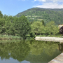 Appartementanlage mit See und bewaldetem Berg im Hintergrund