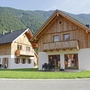 Zwei Holzhäuser vor bewaldetem Berg in Obertraun.