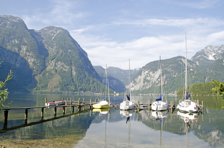 Boote an einem Steg, umgeben von Bergen und einem See in Obertraun.