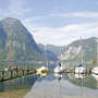 Boote an einem Steg, umgeben von Bergen und einem See in Obertraun.