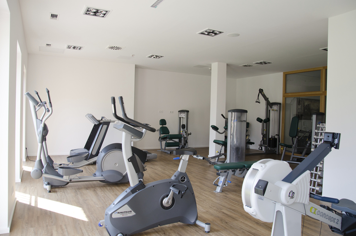 Fitnessraum mit verschiedenen Trainingsgeräten.