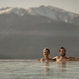 Zwei Personen im Infinity-Pool mit Bergblick in Südtirol.