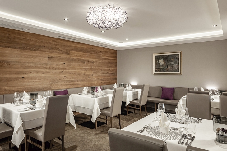 Elegantes Restaurant mit weiß gedeckten Tischen und Kunst an der Wand.