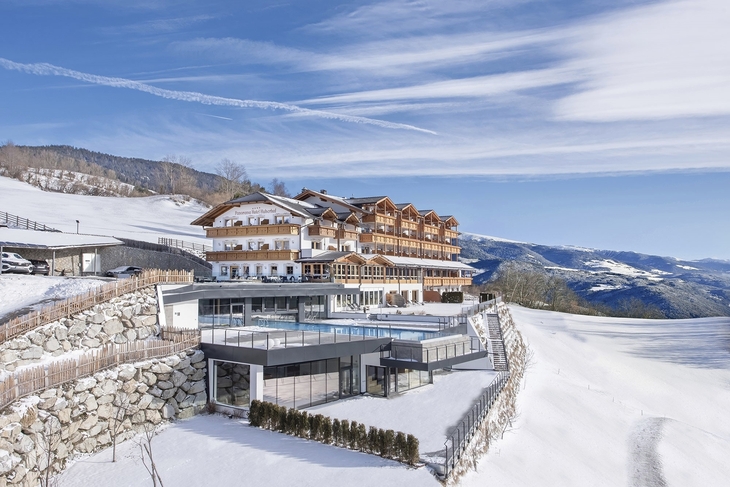 Panoramahotel im Winter mit verschneiter Landschaft und blauem Himmel.