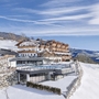 Panoramahotel im Winter mit verschneiter Landschaft und blauem Himmel.