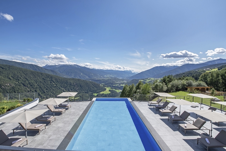Bergpanorama mit Pool und Liegen im Freien bei Sonnenschein