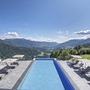 Bergpanorama mit Pool und Liegen im Freien bei Sonnenschein