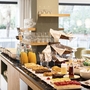 Frühstücksbuffet im Hotel mit Gebäck, Getränken und Geschirr.