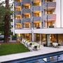 Außenfassade eines Hotels am Abend mit beleuchteten Balkonen und Terrasse.