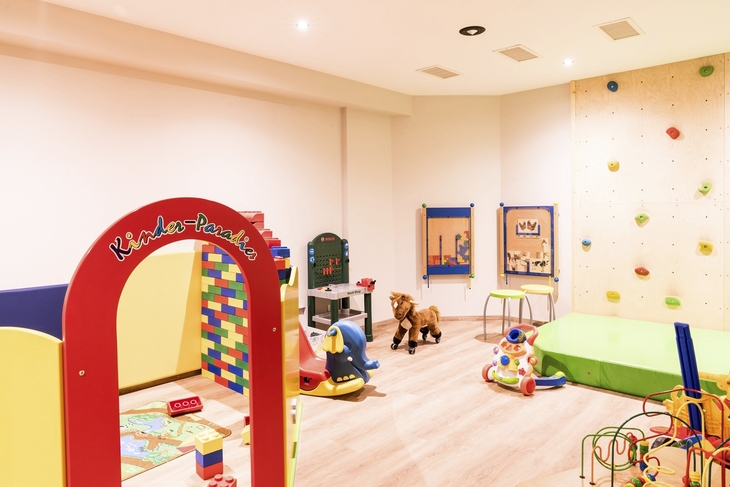 Kinderspielraum mit Spielzeug und Kletterwand im Hotel Flora.