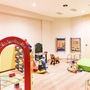 Kinderspielraum mit Spielzeug und Kletterwand im Hotel Flora.