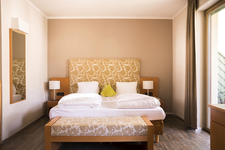 Ein gemütliches Hotelzimmer mit einem großen Doppelbett und heller Dekoration.