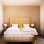Ein gemütliches Hotelzimmer mit einem großen Doppelbett und heller Dekoration.