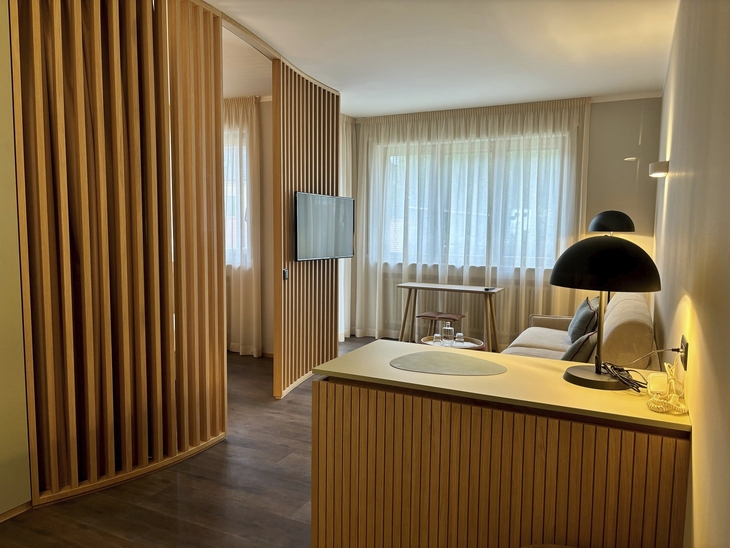 Moderne Hotelsuite mit Holzdekoration und gemütlichem Wohnbereich.