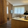 Moderne Hotelsuite mit Holzdekoration und gemütlichem Wohnbereich.