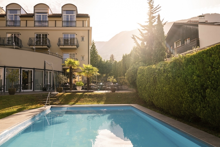 Außenansicht der Villa Laurus mit Pool und Terrasse bei Sonnenschein.