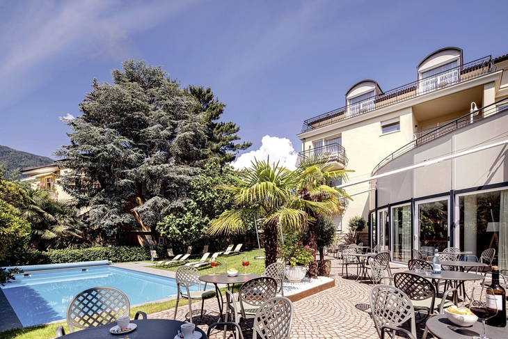 Außenbereich der Hotel Villa Laurus mit Pool, Terrasse und Gartenmöbeln.