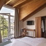 Doppelzimmer mit Holzbalkendecke, Balkon mit Bergblick, Schreibtisch und Schrank.