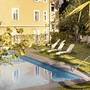 Gartenblick mit Pool und Liegestühlen im Hotel Villa Laurus in Meran.
