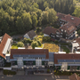 Luftaufnahme eines Erholungswerks mit mehreren Gebäuden und umliegendem Wald.