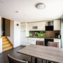 Moderne Küche mit Esstisch, Holzfußboden und Zugang zur Terrasse.