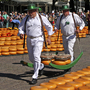 Träger in Weiß transportieren Käse auf dem Markt in Alkmaar, Niederlande.