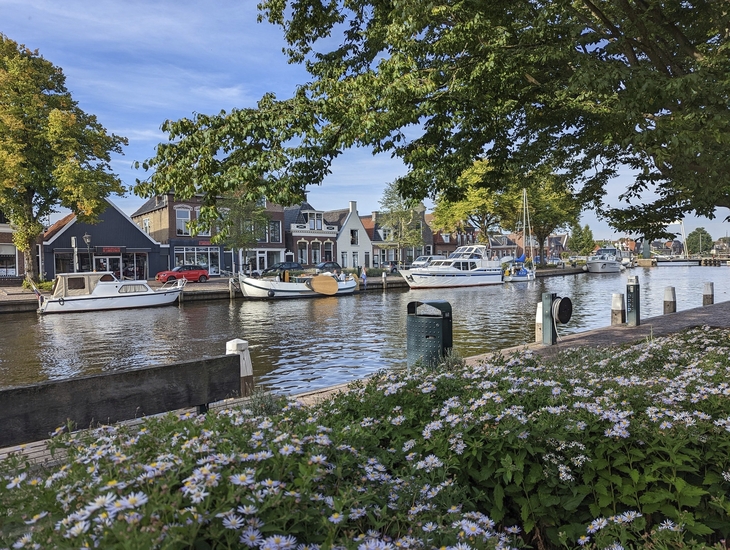 Boote im Kanal vor Häusern in Lemmer, Nordholland, bei sonnigem Wetter.