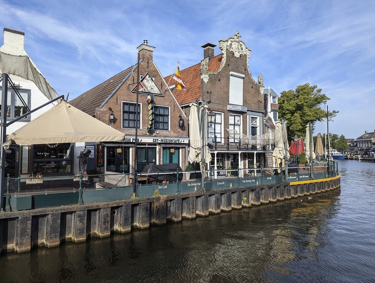 Historische Gebäude am Wasser in Lemmer, Nordholland bei klarem Himmel.