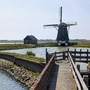 Windmühle in der Landschaft von Texel, Nordholland, mit Wassergraben im Vordergrund