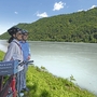 Zwei Radfahrer mit Helmen blicken auf die Donau entlang des Donauradwegs.