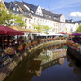 Kanal in Saarburg mit bunten Häusern und Blumen geschmückten Ufer.