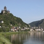 Burg Cochem auf Hügel, umgeben von Stadt und Flusslandschaft.