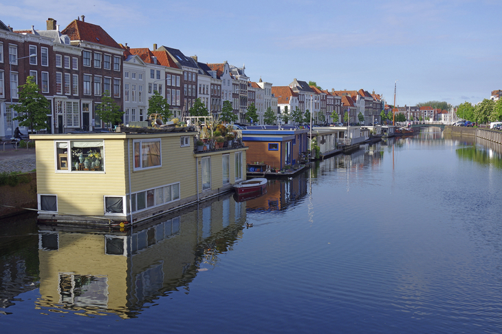Hausboote und Gebäude entlang eines Kanals in Middelburg bei sonnigem Wetter.